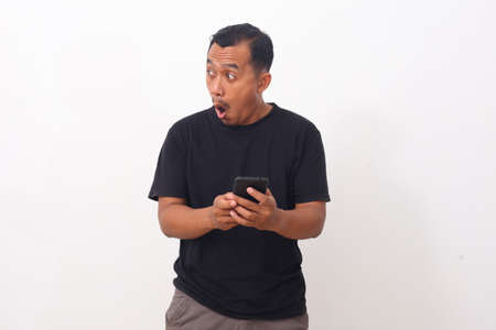 Wow and shocked face of Asian man while looking at sideways. Isolated on white backgroundの写真素材