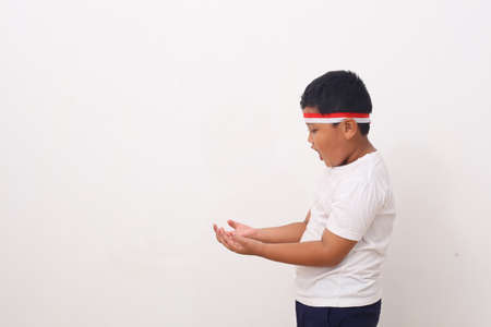 Wow and shocked face of Asian boy point to present an empty space of content. Advertising model concept.の写真素材
