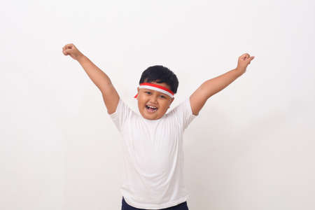 Portrait of happy asian boy standing while clenching fist. Isolated on white backgroundの写真素材