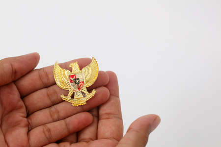 Hand with Garuda Pancasila. Indonesia independence day 17th August. Isolated on whiteの写真素材