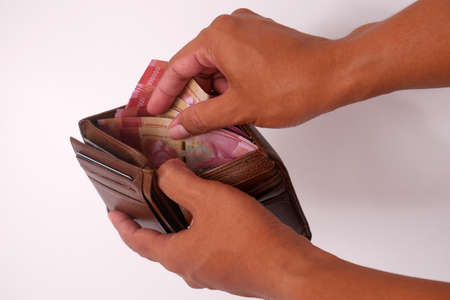 Man hand take and showing money from his wallet. Isolated on white backgroundの写真素材