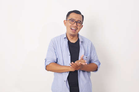 Portrait of happy Asian man in blue shirt on isolated white background.の写真素材