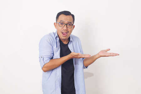 Portrait of asian man showing something on empty space. Isolated on white with copyspace