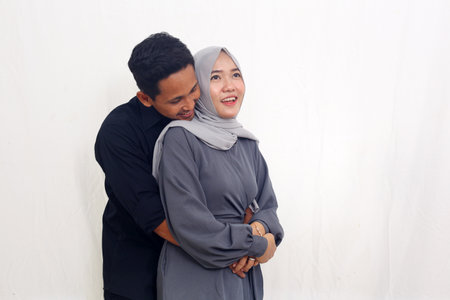 Happy asian muslim couple standing while smiling. Isolated on white background