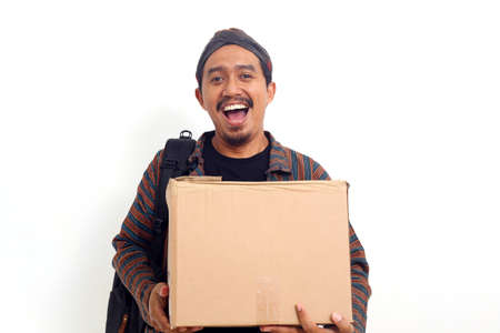 Happy Asian man carrying a cardboard box. Isolated on white backgroundの写真素材