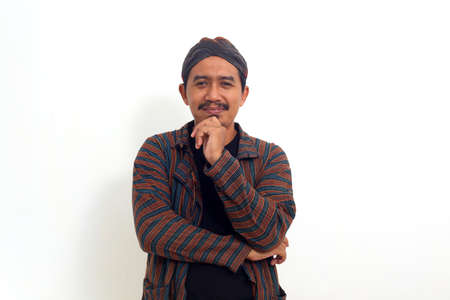 wise and considerate mature asian man,smiling while holding chin