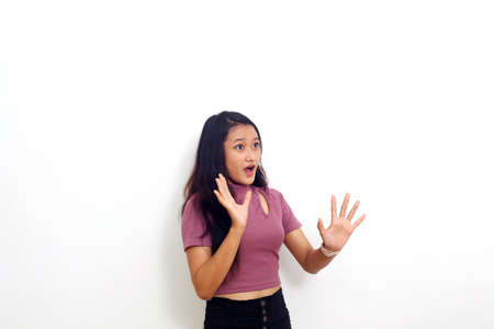 Asian girl wearing pink dress shocked isolated on white backgroundの写真素材