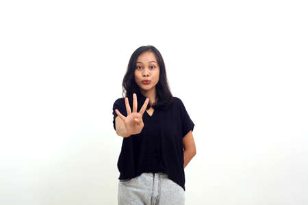 asian woman raising hand and showing four fingers. isolated on whiteの写真素材