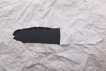 White crumpled paper texture with hole in the paper with torn sides