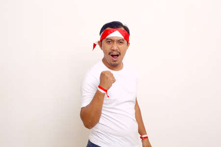Passionate asian man standing while clenching his hand. Indonesian independence day concept