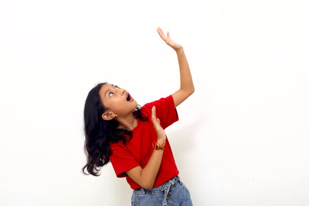 Wow and amazed asian little girl standing while receive something from above. Isolated on whiteの写真素材