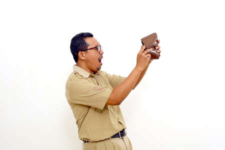 Surprised Indonesian government employees standing while checking his wallet. Isolated on whiteの写真素材