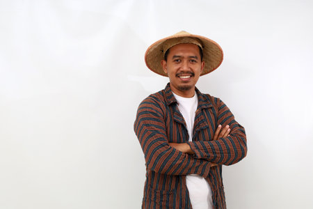 Happy asian farmer standing with folded arm. Isolated on white backgroundの写真素材