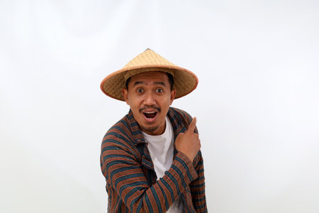 Happy asian farmer standing while pointing something beside him. Isolated on white backgroundの写真素材