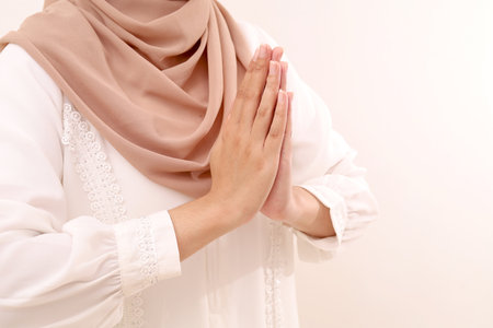 Close up photo of muslim woman's hand making greeting or welcoming gesture. Isolated with copyspaceの写真素材
