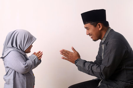 Muslim family and kid greeting and asking forgiveness shaking hand on ramadan and eid mubarakの写真素材