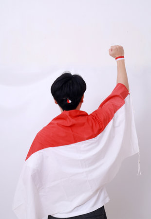 Back view of Asian man celebrate Indonesia Independence Day on 17 August by wearing Indonesian flag.の写真素材