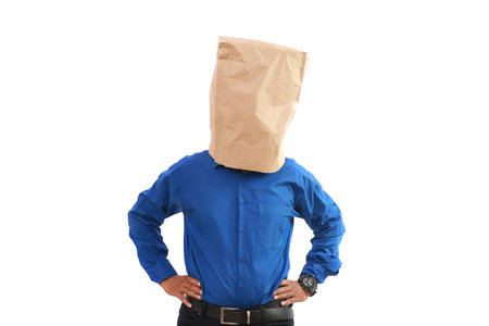 Businessman with a paper bag standing with hands on waistの写真素材