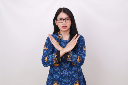 Asian female in batik korpri, indonesian traditional uniform crossing her handsの写真素材