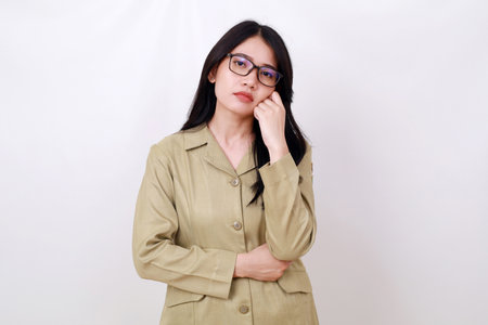 Sad young indonesian government worker standing while doing nothingの写真素材