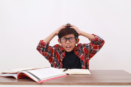 Stressed asian student holding his head, suffering from headache. Isolated on white background