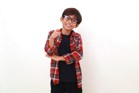 Happy asian boy standing while pointing on you or camera. Isolated on whiteの写真素材