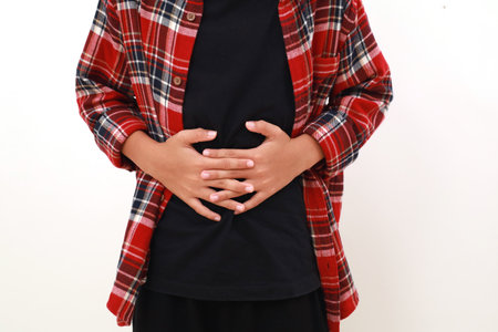 Close up photo of hands asian boy holding his stomachの写真素材
