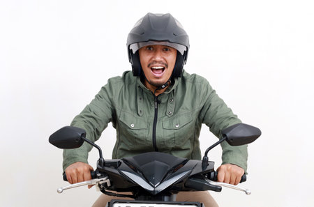 Wow expression of asian man riding a motorcycle. Isolated on white backgroundの写真素材