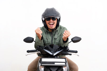 Wow excited asian man riding motorcycle while making fist hands. Isolated on white backgroundの写真素材