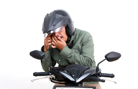 Asian man having trouble with his eyes. Some dust gets into his eyes. Isolated on white backgroundの写真素材