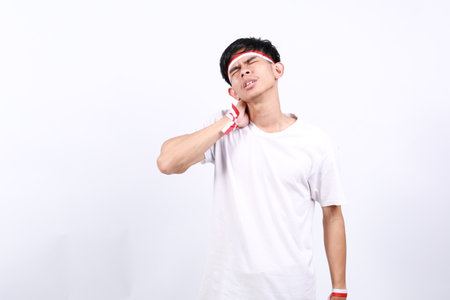 Asian young boy with red white ribbon for celebrating Indonesia independence day standing having...