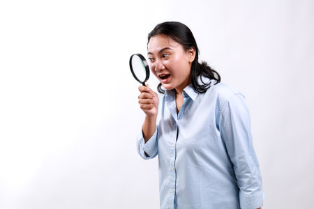 Excited woman in formal clothes look through magnifying glass with amazed face, found interesting...