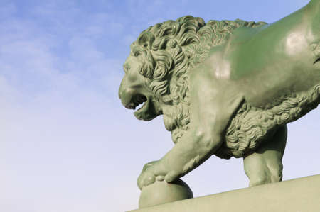 A bronze statue of a lion on the bank of the river Neva in St. Petersburg, Russiaの写真素材