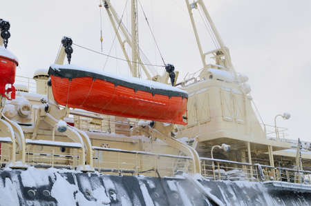 Lifeboat on the side of the ship. In snow.