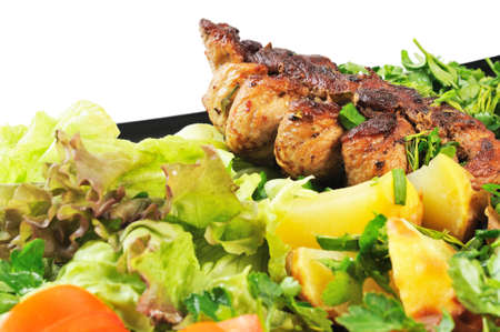 Grilled meat and potatoes. Decorated with tomatoes, lettuce and herbs.の写真素材