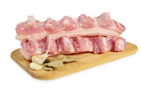 Raw bacon with ribs on a wooden cutting board  Isolated on white の写真素材