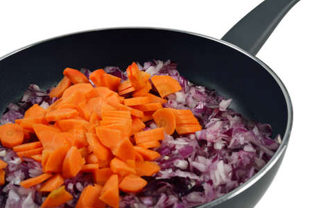 Onions and carrots in a frying pan  Isolated on white の写真素材