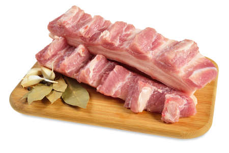 Raw bacon with ribs on a wooden cutting board  Isolated on white の写真素材