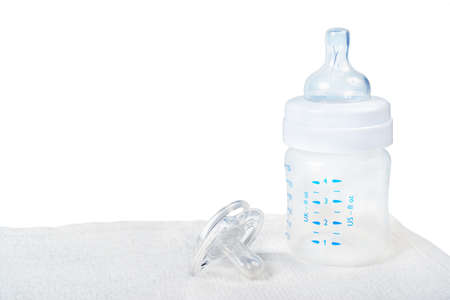 Baby bottle and pacifier on towel 