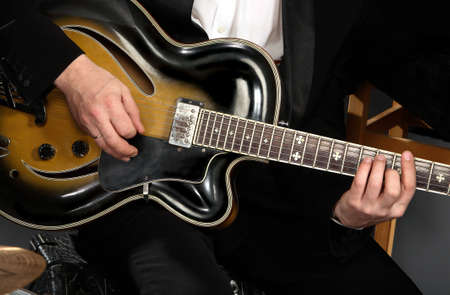 electric guitar close-up with fingers playing it