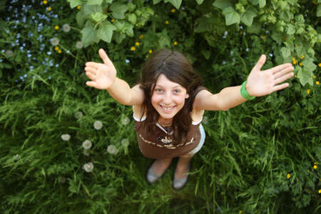 The girl with a happy smile on a green grass の写真素材