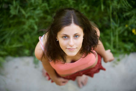 The young girl with blue eyes and dark hair looks in a shot, having lifted a headの写真素材