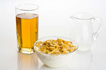 Big glass of apple juice and  corn-flakes with milk