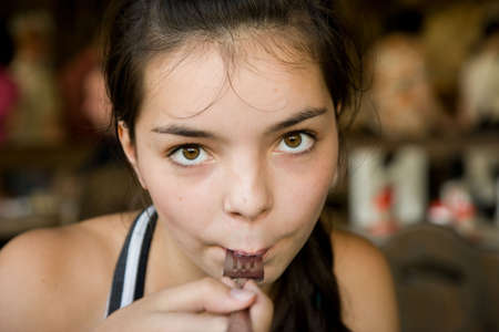 Dark-haired girl-teenager eating in cafe close upの写真素材