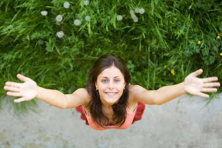The girl with a happy smile on a green grass の写真素材