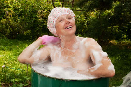 The elderly woman washes in the caskの写真素材