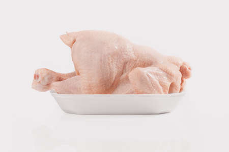 Side view of fresh raw chicken isolated on whiteの写真素材