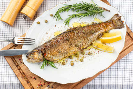 Baked sibas fish fillet garnished with greens