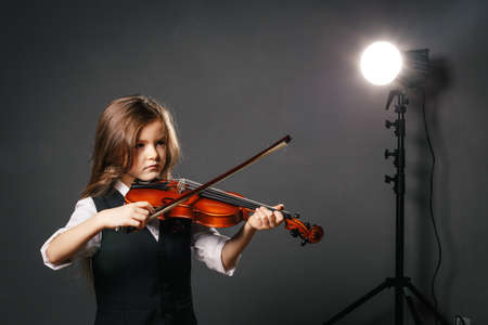 Beautiful girl with long hair playing on violinの写真素材