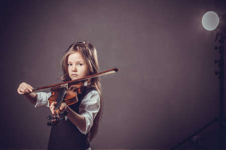 Beautiful girl with long hair playing on violinの写真素材